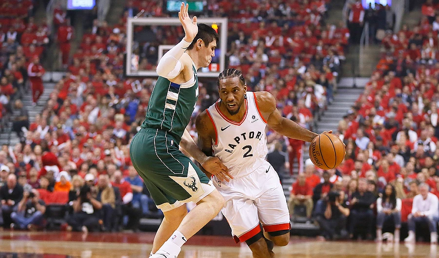 Raptors forward Kawhi Leonard dribbles the ball around Milwaukee Bucks forward Ersan Ilyasova. (USA TODAY Sports)