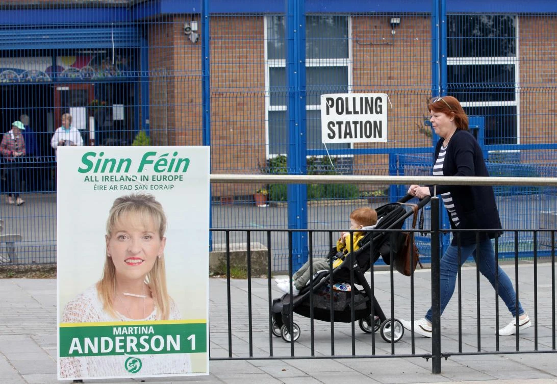 A woman walks past a polling station as voting for the European Parliament elections got underway, in west Belfast, northern Ireland on May 23, 2019. (AFP)