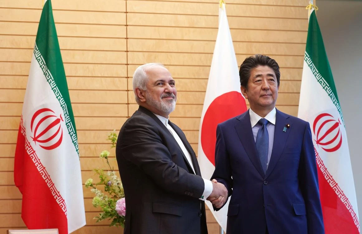 Iranian Foreign Minister Mohammad Javad Zarif, left, and Japanese Prime Minister Shinzo Abe shake hands during Zarif’s visit in Tokyo on May 16, 2019. (AFP)
