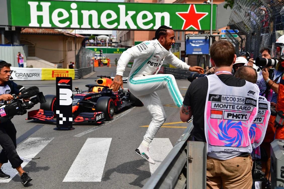 Mercedes’ British driver Lewis Hamilton runs toward fans as he celebrates winning the pole position after the qualifying session at the Monaco street circuit ahead of the Formula 1 Grand Prix on Sunday. (AFP)