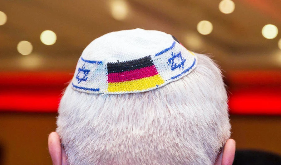 Photo taken on June 10, 2014 in Frankfurt am Main, western Germany, shows a man wearing a Jewish kippa skullcap with the flags of Germany and Israel. (AFP)