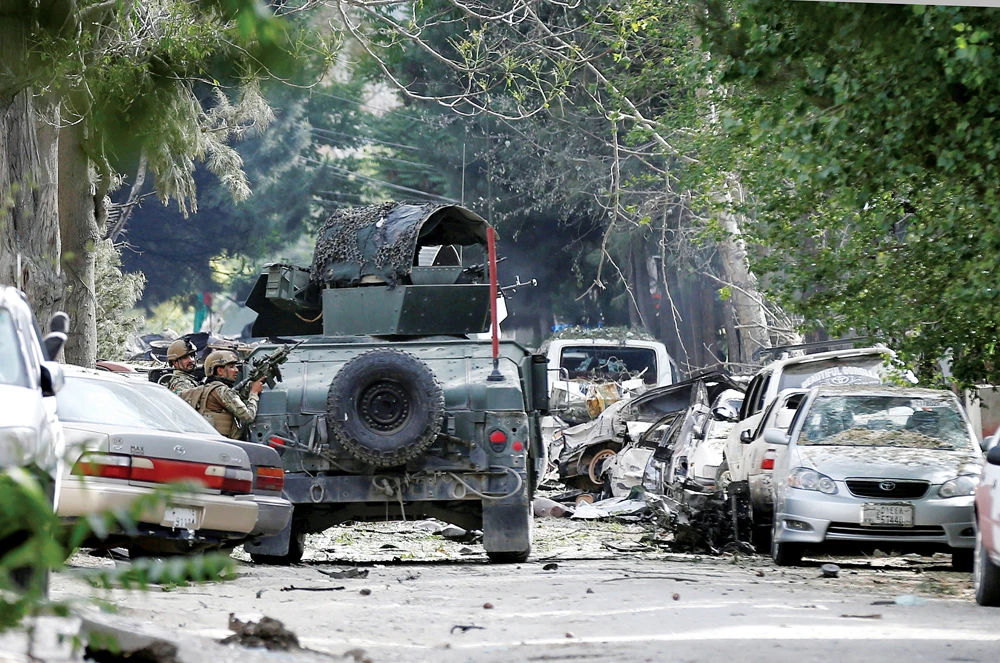 Afghan forces take position during an attack by gunmen in Kabul on May 8. Various countries are making efforts to find a solution to the Afghan problem. (Reuters)