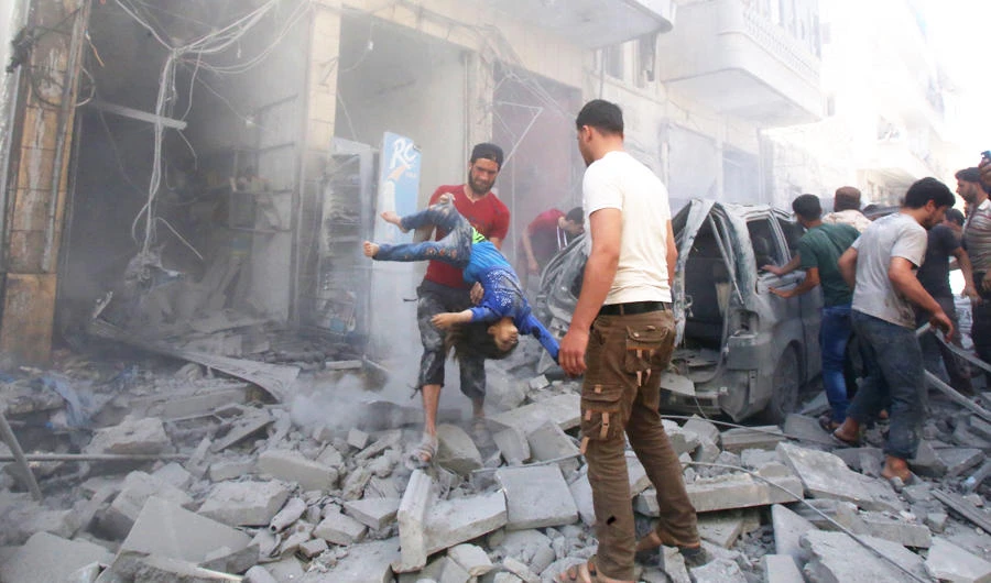 A man evacuates a young casualty following a reported air strike by regime forces and their allies in the jihadist-held Syrian town of Maaret Al-Noman in the southern Idlib province, on May 26, 2019. (AFP)