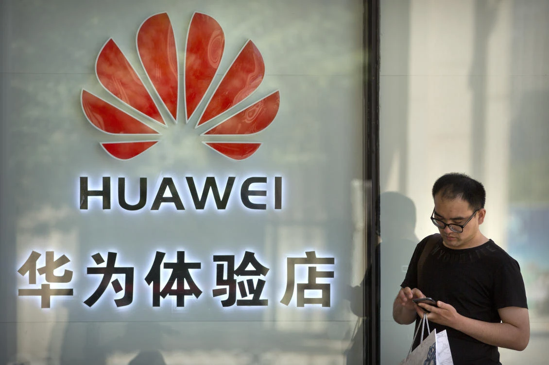 A man uses his smartphone outside of a shop selling Huawei products at a shopping mall in Beijing, Wednesday, May 29, 2019. (AP/Mark Schiefelbein)