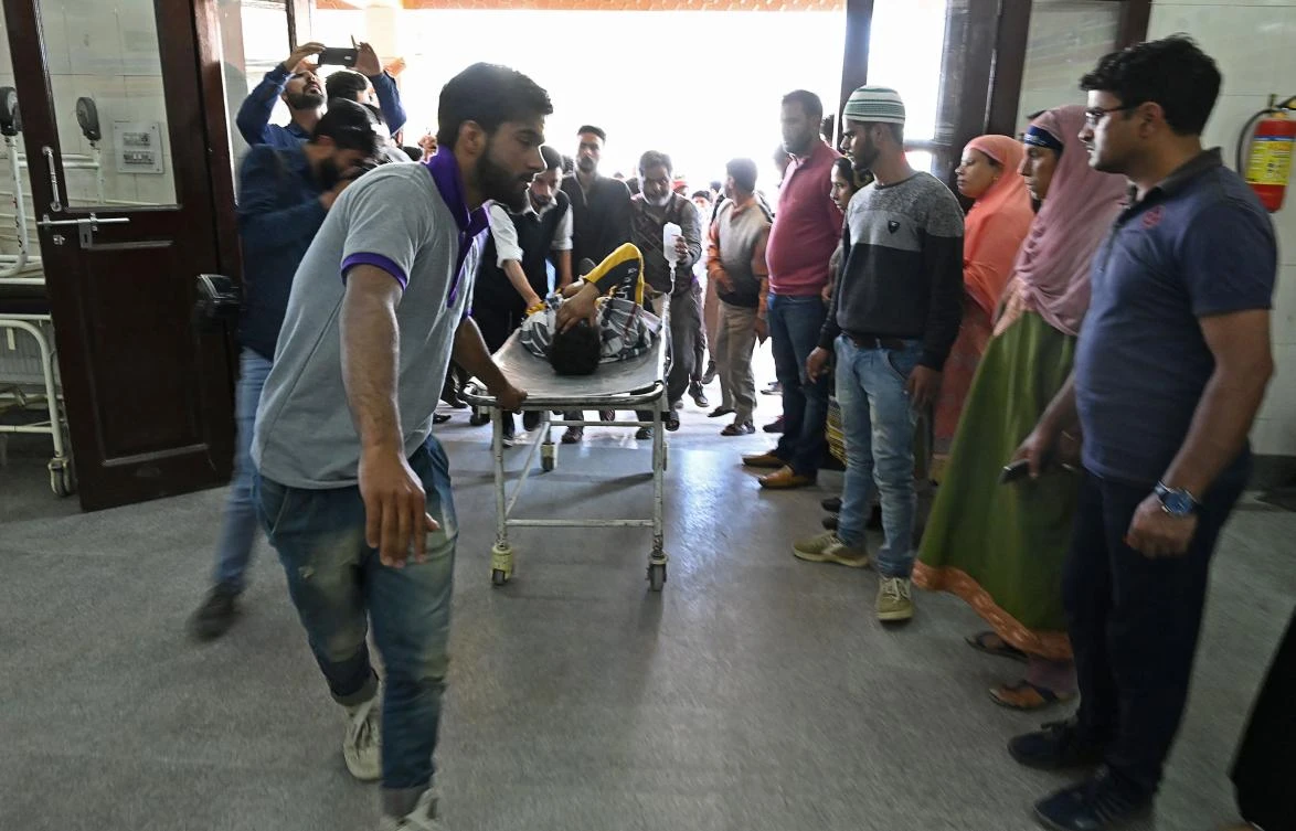 Kashmiri volunteers and medical workers transport a person injured during clashes with Indian government forces at a hospital in Srinagar on May 29, 2019. (AFP)