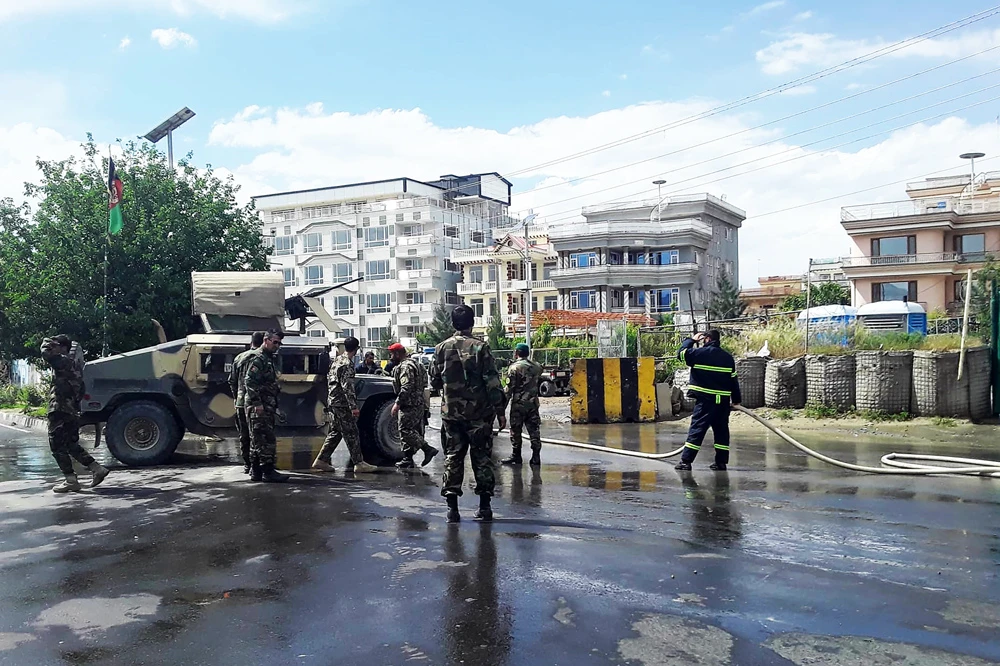 Afghan security personnel and firefighters clean the site of a suicide attack near the Marshal Fahim Military Academy base in Kabul on May 30, 2019. (AFP / THOMAS WATKINS)