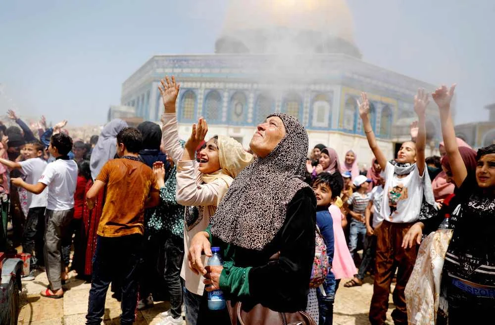 Women cool themselves down in a stream of water as Palestinians gather for the Friday prayer at Al Aqsa mosque. (AFP)