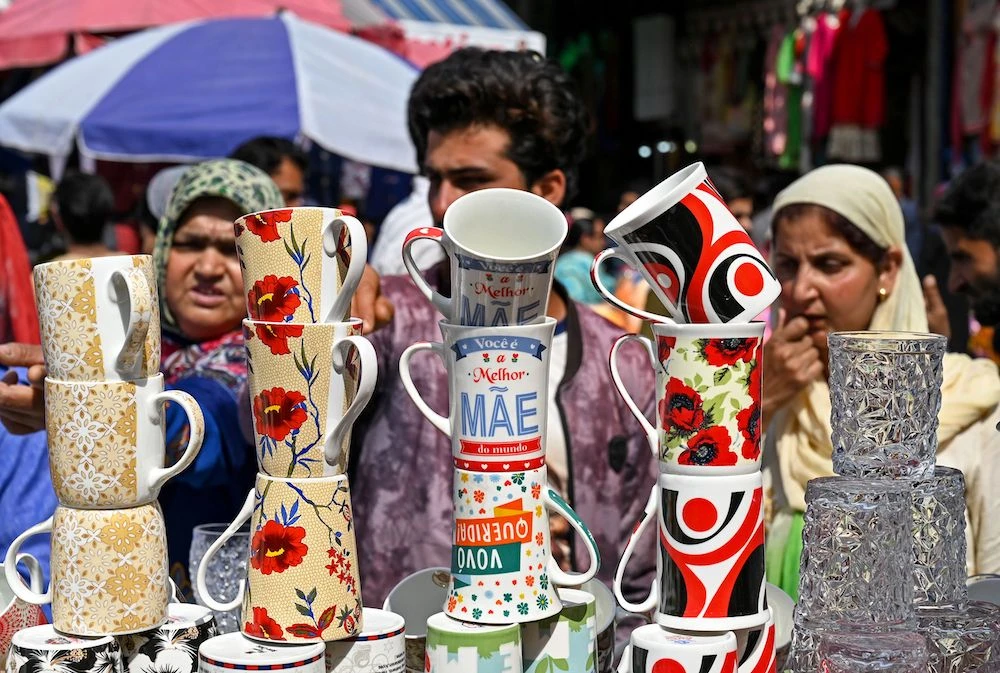Kashmiri Muslims look at mugs being sold at a market ahead of Eid Al-Fitr in Srinagar. (AFP)