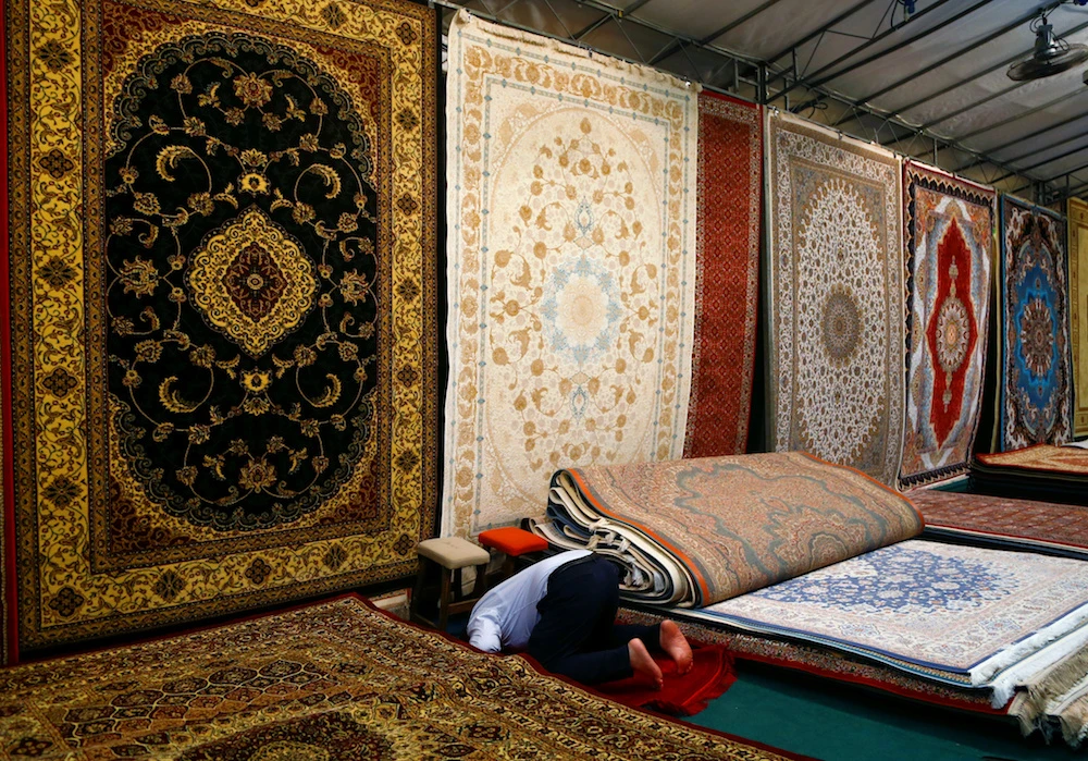 A shopkeeper prays at the Geylang Serai Ramadan bazaar ahead of Eid Al-Fitr in Singapore. (Reuters)