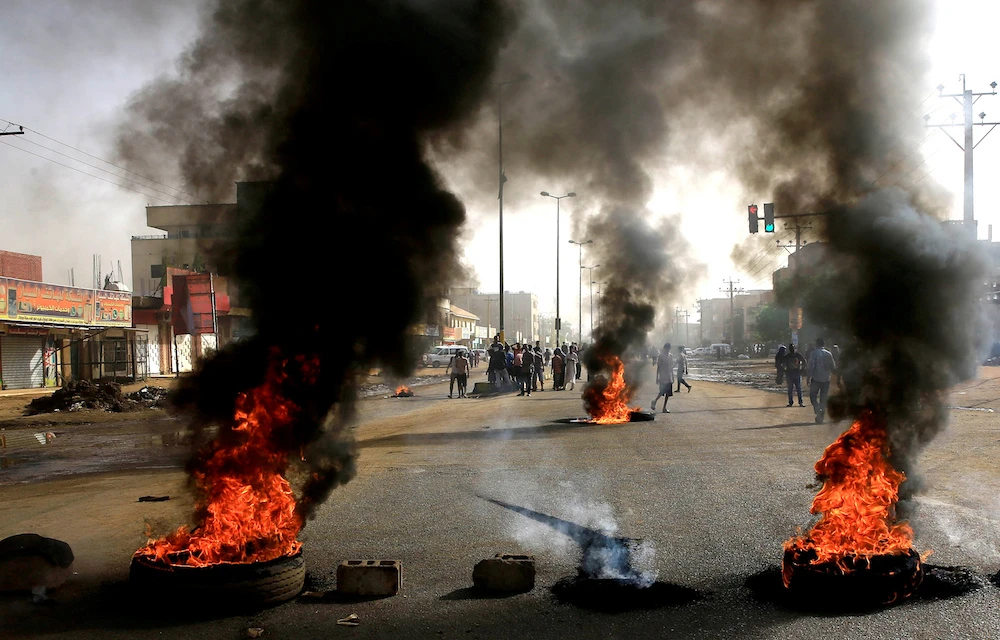 Sudanese protesters use burning tires to erect a barricade on a street, demanding that the country’s Transitional Military Council hand over power to civilians, in Khartoum, Sudan. (Reuters)