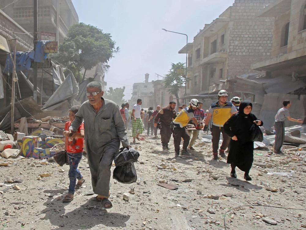 Members of the Syrian Civil Defence carry a wounded man following an air strike on the town of Maaret Al-Numan. (AFP)