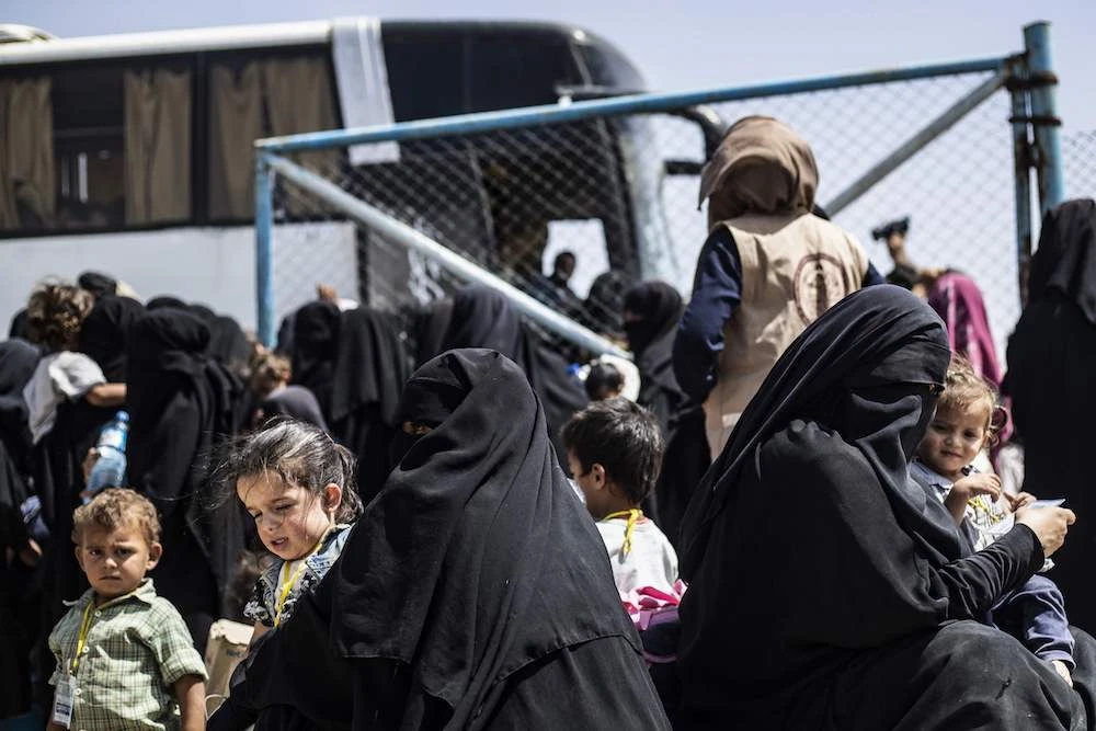 Displaced people prepare to board a bus outside the Al-Hol camp in Al-Hasakah governorate in northeastern Syria, as Kurdish authorities started sending home 800 Syrian women and children who had been evacuated from Daesh’s “caliphate” earlier this year. (AFP)