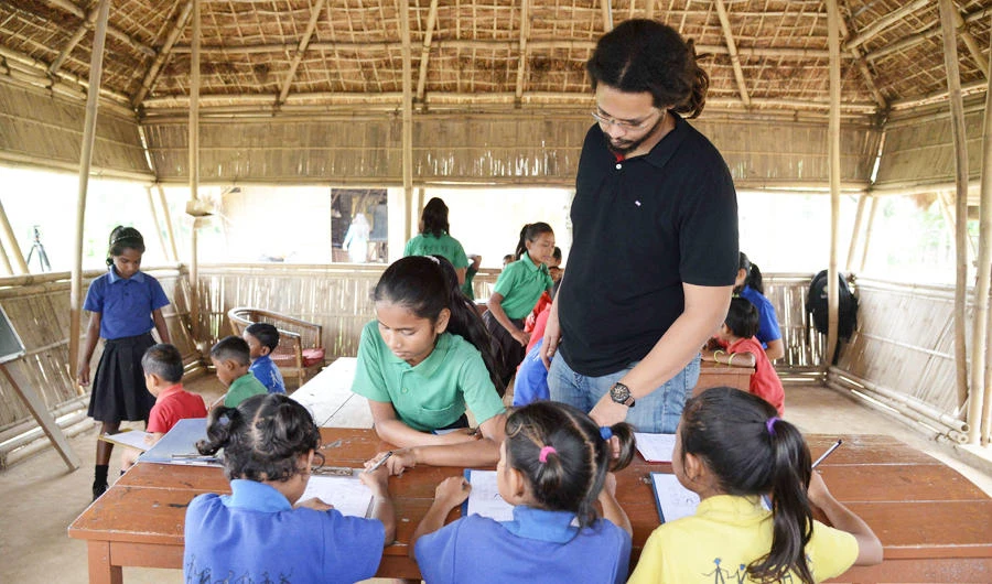 In this photo taken on May 20, 2019, founder of the school, Mazin Mukhtar (C standing), interacts with students during a class at the Akshar Forum school in Pamohi on the outskirts of Guwahati. One school in north-eastern India has taken a novel approach to addressing the scourge of plastic waste by accepting the stuff as "fees". (AFP)