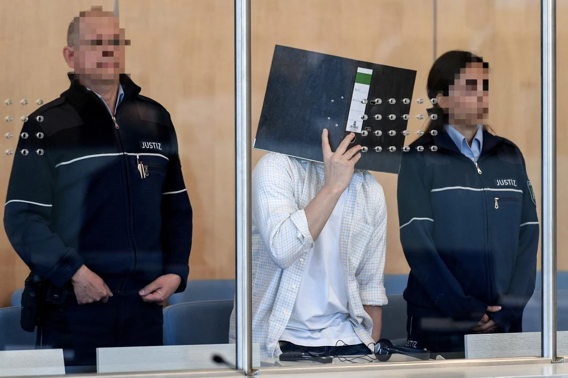 Defendant Sief Allah H. (C) covers his face as he arrives in a courtroom of the higher regional court in Duesseldorf, Germany, 07 June 2019. (EPA)