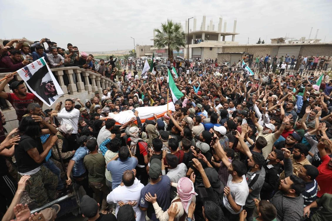 Syrians waving rebel flags and portraits of Abdelbasset Al-Sarout during the rebel fighter's funeral in Al-Dana, Idlib region, near the border with Turkey. (AFP)