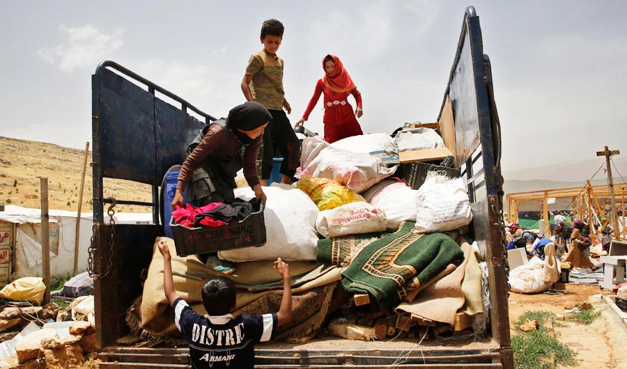 A Syrian family loads their belongings on a pickup, as they evacuate an informal refugee camp after a fight broke out last week between camp residents and Lebanese firefighters who arrived to put out a fire, in Deir Al-Ahmar, east Lebanon, Sunday, June 9, 2019. (AP)