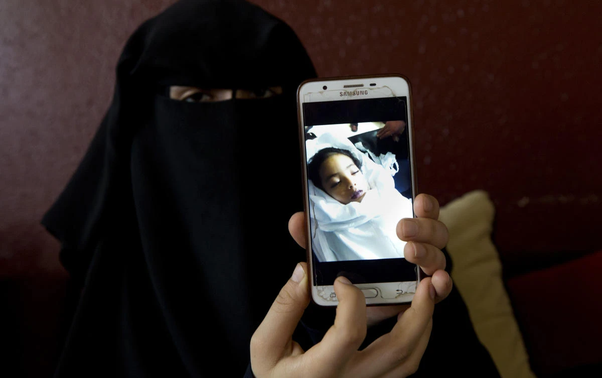 Muna Awad, mother of Palestinian preschooler Aisha a-Lulu, shows a photo of her daughter while in a Jerusalem hospital, at the family home in Bureij refugee camp in central Gaza Strip. (AP)