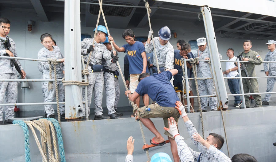 Rescued Filipino fishermen transfer to another ship as they head back to shore in Occidental Mindoro province, Philippines on Friday June 14, 2019. (AP)
