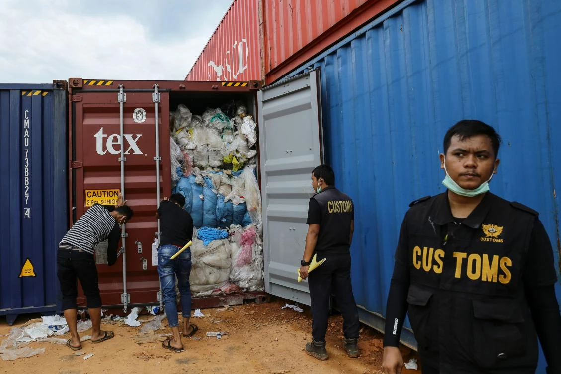 Indonesian customs officers examine one of 65 containers full of imported plastic rubbish, at the Batu Ampar port in Batam. (AFP)
