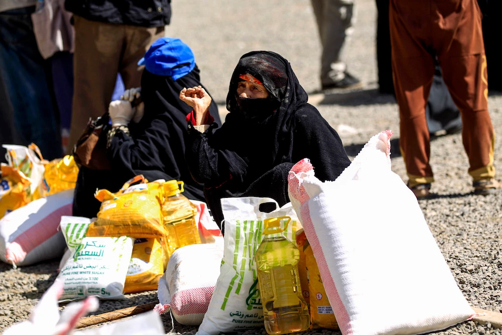 Women collecting food-aid in Houthi-controlled Sanaa. The World Food Programme, accused the militia of diverting aid away from its intended recipients. (AFP/File photo)
