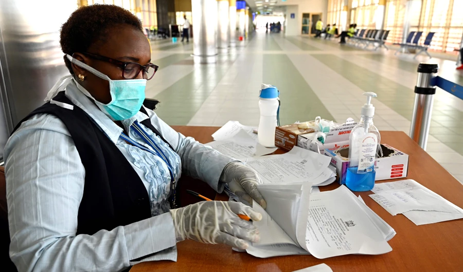 A port health officials wearing a mask works at the arrival terminal are screened by port health service, at the Jommo Kenyatta International airport in Nairobi on June 17, 2019. (AFP)