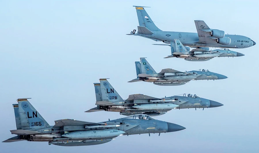 A handout picture provided by the Saudi Ministry of Defence on June 16, 2019 shows Saudi F-15 Eagles flying in formation with their US Air Force counterparts and a USAF KC-135E Stratotanker jet (top) in the US CENTCOM area of responsibility, on June 2. (AFP)
