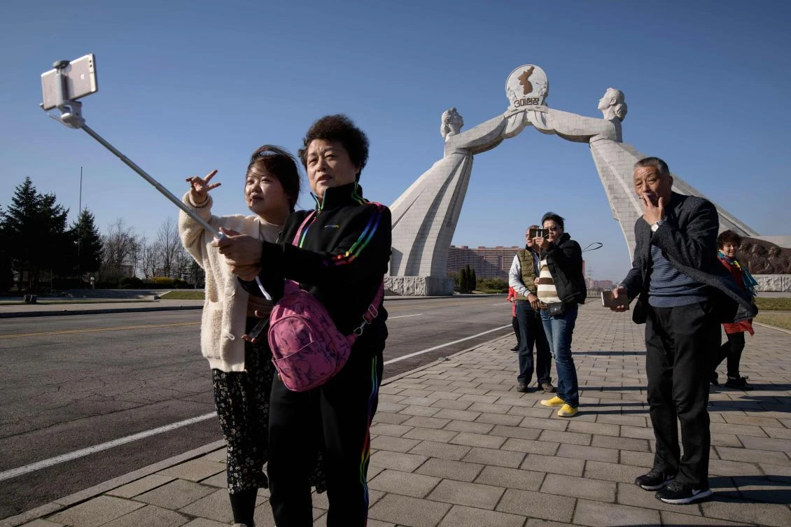 Above, Chinese tourists pose for photos before the Three Charters monument in Pyongyang. (AFP)