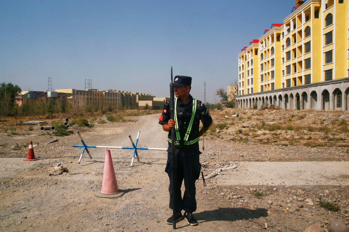A Chinese police officer takes his position by the road near what is officially called a vocational education center in Yining in Xinjiang Uighur Autonomous Region, China. (Reuters)