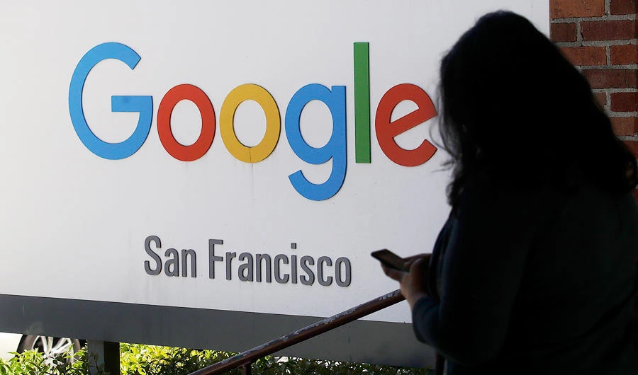 In this May 1, 2019, file photo, a woman walks past a Google sign in San Francisco. Google is making a $1 billion commitment to address the soaring price of housing in the San Francisco Bay Area, a problem that the internet company and its Silicon Valley peers helped create as the technology industry hired tens of thousands of high-paid workers. (AP)