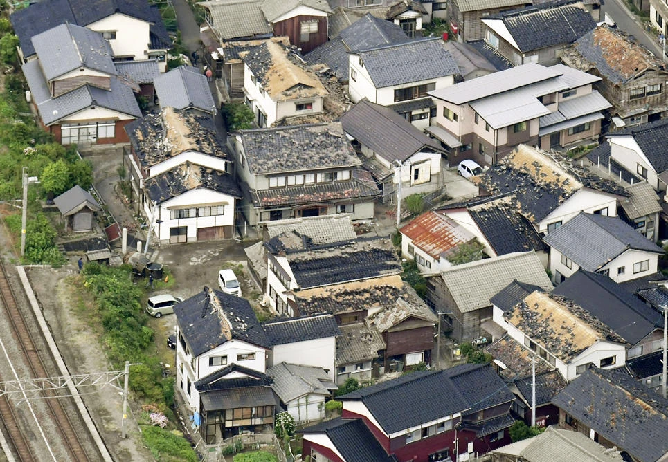 This aerial view shows damaged roof tiles of residential houses in Tsuruoka, Yamagata prefecture, northwestern Japan, ON June 19, 2019, after an earthquake. (Kyodo News via AP)