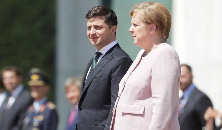 German Chancellor Angela Merkel, right, stands next to Ukraine's President Volodymyr Zelenskiy with military honors for a meeting at the chancellery in Berlin, Germany, Tuesday, June 18, 2019. (AP)