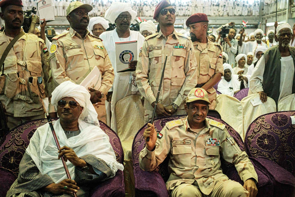 Sudanese General Mohamed Hamdan Dagalo, also known as Himediti, deputy head of Sudan's ruling Transitional Military Council (TMC) and commander of the Rapid Support Forces (RSF) paramilitaries, sits next to a tribal leader Sidig Wada during a meeting with his supporters in the capital Khartoum on June 18, 2019. (AFP / Yasuyoshi Chiba)