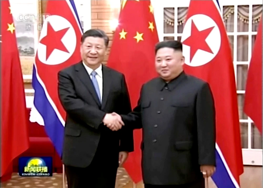 A grab from a video footage run by China’s CCTV shows Chinese President Xi Jinping, left, and North Korean leader Kim Jong Un shaking hands before their meeting in Pyongyang. (CCTV via AP)