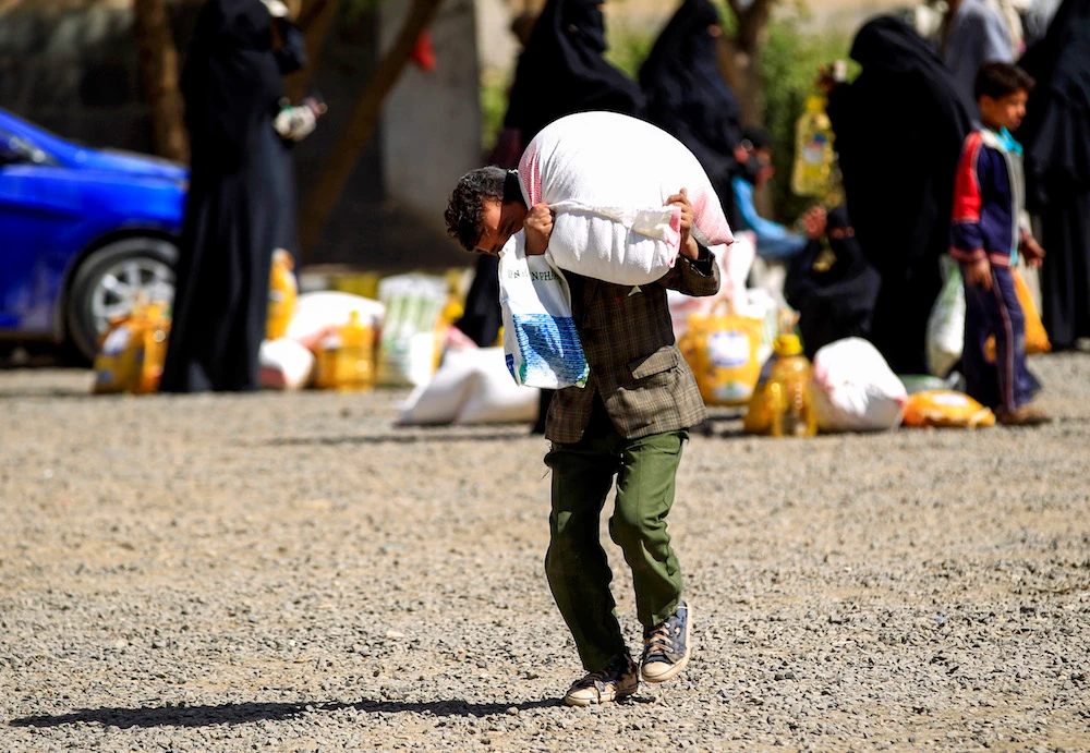 A Yemeni child receives food aid in Sanaa earlier this year. (AFP/File photo)