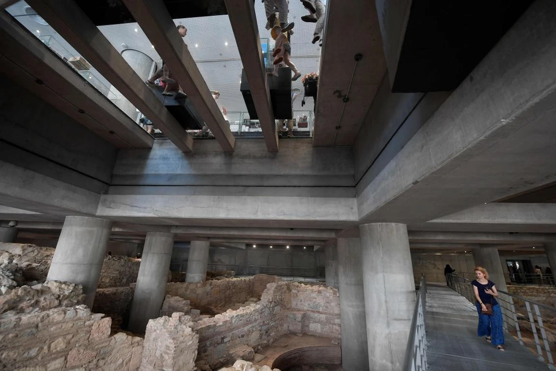 People visit the excavation beneath the Acropolis museum in Athens, on its opening day on June 21, 2019 which coincides with ten years of museum operation. (AFP)