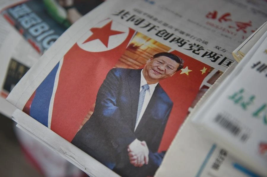 A newspaper featuring a front page photo of Chinese President Xi Jinping shaking hands with North Korean leader Kim Jong Un (not seen) during Xi’s visit to Pyongyang. (File/AFP)