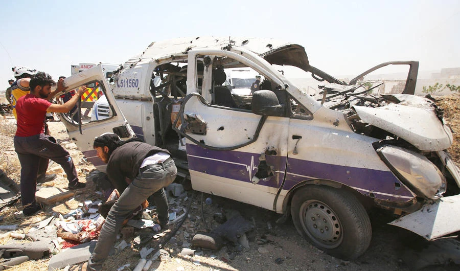 Syrian rescuers help a badly wounded fellow rescuer following a reported regime air strike which targeted an ambulance in the town of Maaret al-Numan in northwest Syria on June 20, 2019. (AFP)