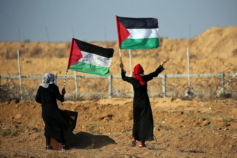 Women wave Palestinian flags during a protest at the Israel-Gaza border fence, in the southern Gaza Strip June 21, 2019. (Reuters)