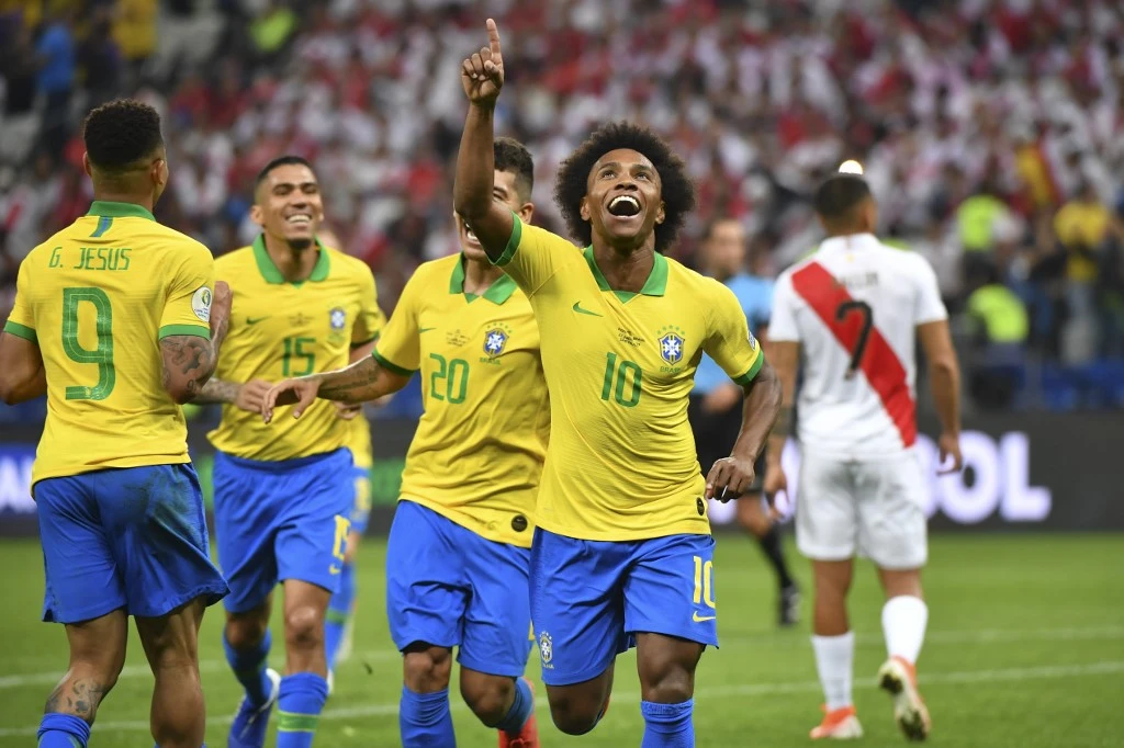 Brazil’s Willian, right, celebrates after scoring against Peru during their Copa America football tournament group match at the Corinthians Arena in Sao Paulo, Brazil, on June 22, 2019. (AFP)