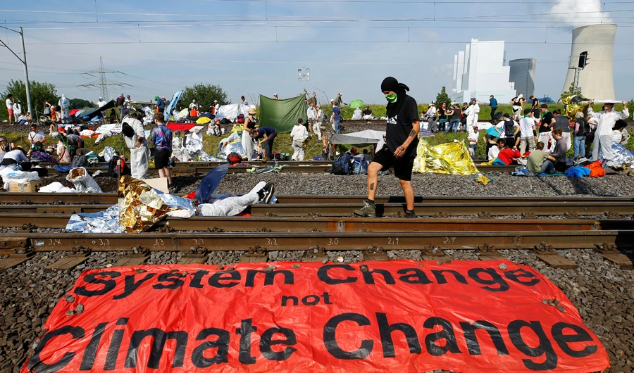 Environmental activists block the rails during a protest against climate change outside the Neurath Power Station near Rommerskirchen, Germany. (Reuters)