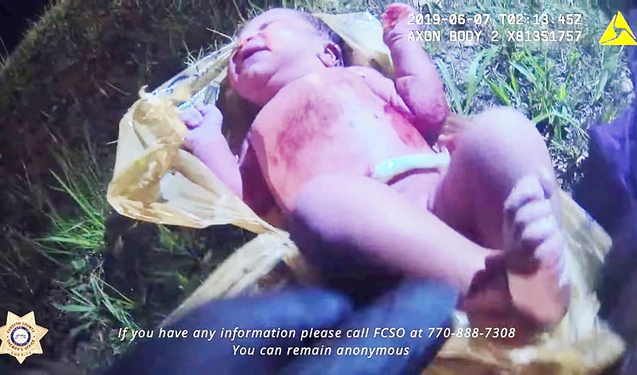 A Georgia Sheriff saves a baby found in a plastic bag, in this screen grab taken from social media June 25, 2019. (Reuters)
