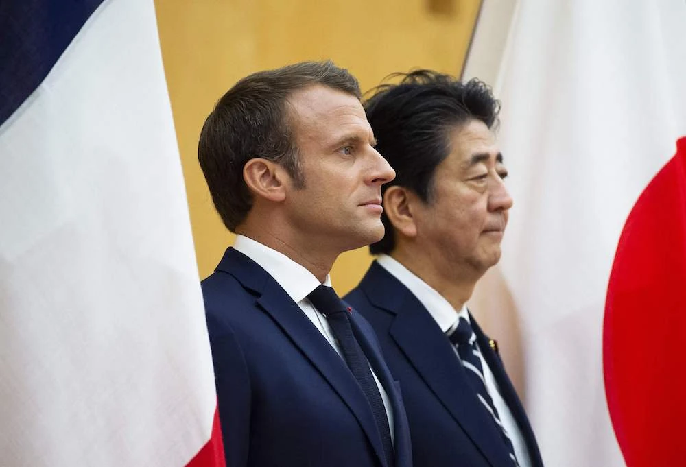 Japan’s Prime Minister Shinzo Abe (R) stands beside France’s President Emmanuel Macron during an official ceremony at the prime minister’s official residence in Tokyo on June 26, 2019. (AFP)