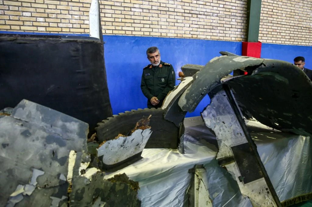 General Amir Ali Hajizadeh, center, Iran’s head of the Revolutionary Guard’s aerospace division, looks at debris from a downed US drone put on display by the Revolutionary Guard in Tehran on June 21, 2019. (Tasnim News/AFP)