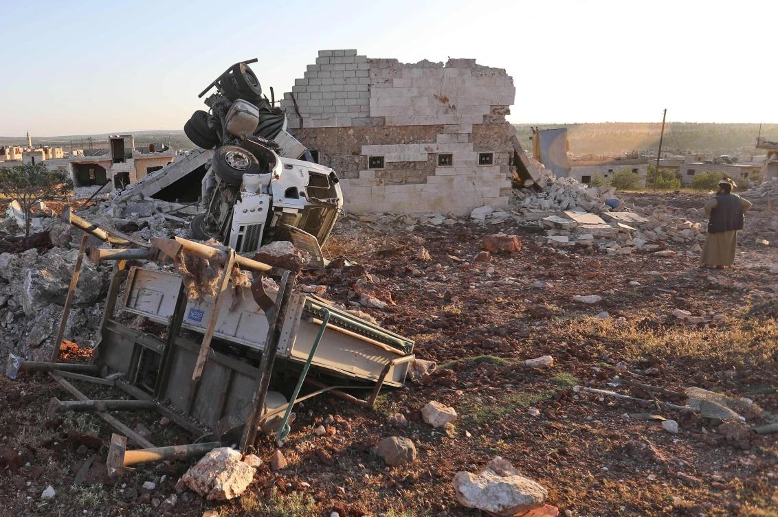 A man gazes at rubble and damaged vehicles following reported air strikes in Idlib province. Turkey has warned that the latest shelling and mortar attack on one of its observation posts in Syria’s Idlib region, which left one soldier dead and three others injured, would be punished. (AFP)