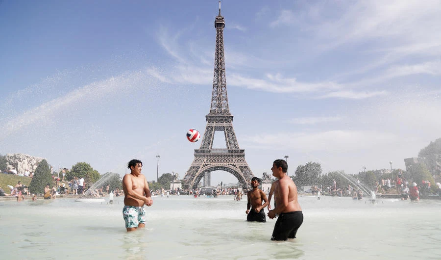 People play as they bathe in the Trocadero Fountain in front of the Eiffel Tower in Paris during a heatwave on June 28, 2019. (AFP)