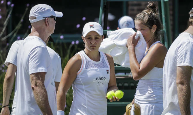 Australia's Ashleigh Barty, center left, and Germany's Julia Goerges, center right, attend a practice session ahead of the Wimbledon Tennis Championships in London on June 29, 2019. (AP Photo/Ben Curtis)