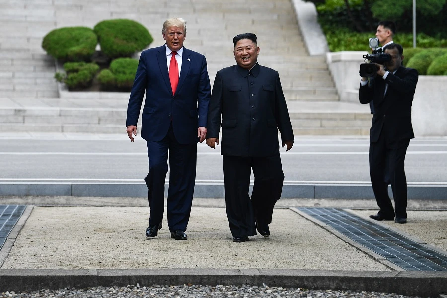 North Korea's leader Kim Jong Un walks with US President Donald Trump north of the Military Demarcation Line that divides North and South Korea, in the Joint Security Area (JSA) of Panmunjom in the Demilitarized zone (DMZ) on June 30, 2019. (AFP)