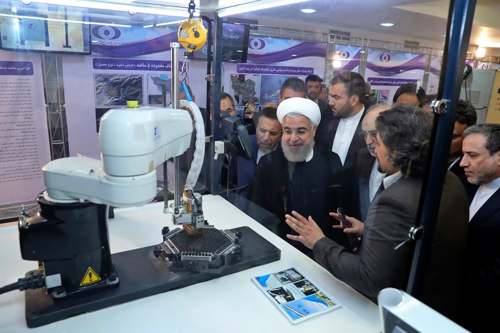 In this April 9, 2018, file photo, released by an official website of the office of the Iranian Presidency, President Hassan Rouhani listens to explanations on new nuclear achievements at a ceremony to mark "National Nuclear Day," in Tehran. (Iranian Presidency Office via AP)