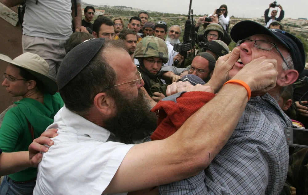 Baruch Marzel, an Israeli right-wing extremist from the Jewish settler community in the divided West Bank town of Hebron, clashes with a fellow Israeli left-wing activist during a protest against settlements in Hebron on May 8, 2009. (AFP file photo)