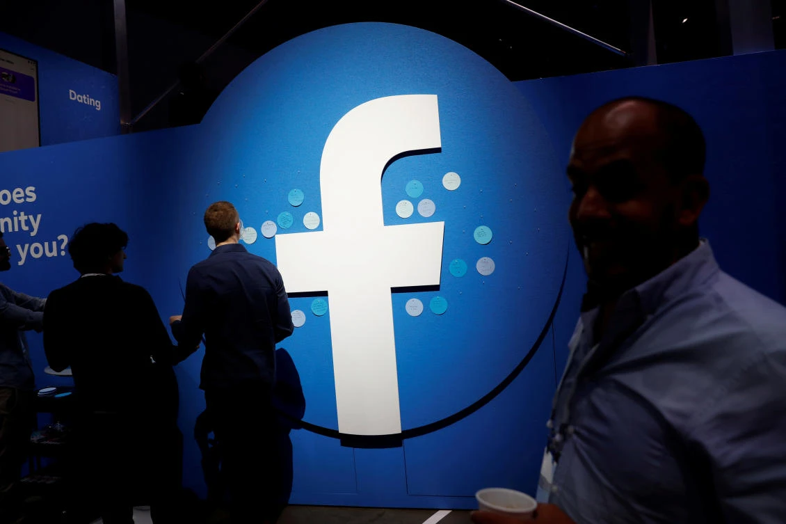 Attendees walk past a Facebook logo during Facebook Inc's F8 developers conference in San Jose, California, U.S., April 30, 2019. (Reuters)